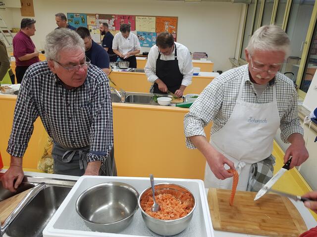 Georg Lipp (rechts) filetiert gekonnt die Lachsseite und schneidet diese dann in ganz kleine Stücke zu Tartar. Karl Rupp hat schon einmal die Gewürze zum abschmecken hergerichtet. | Foto: Otto Killensberger