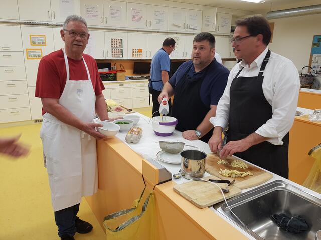 Die Spargelspitzen werden noch klein geschnitten und blanchiert. Von links Willi Buhmeier, Johannes Schuster schlägt die Sahe für die Suppe, während Dr. Roland Ziegler die Spargespitzen klein schneidet.