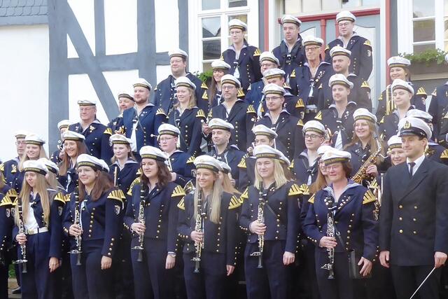 Der Musikzug Battenberg hat sich zum Gruppenfoto am Alten Rathaus aufgestellt. Rechts mit dem Dirigentenstab steht der Musikalische Leiter Niklas Ludwig.