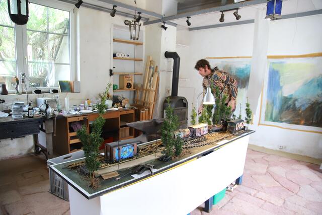 Ludwig Glöcklhofer, Umwelt-gutachter aus Zürich, ist Aktiv-Mitglied auch im Bahnpark Augsburg und hat die Waggons einer Modelleisenbahn von internationalen Streetart-Künstlern bemalen lassen. Im Hintergrund Bilder von Setare, unserer Künstlerin aus dem Iran.