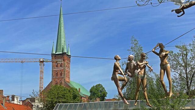 Der Verein Defacto Art macht mit einer Installation auf die Kunsttankstelle aufmerksam. Es handelt sich um eine „Verkündigung“, bestehend aus einer Gruppe von auf einem Drahtseil balancierenden Schaufensterpuppen. Foto: Helmut Kuzina