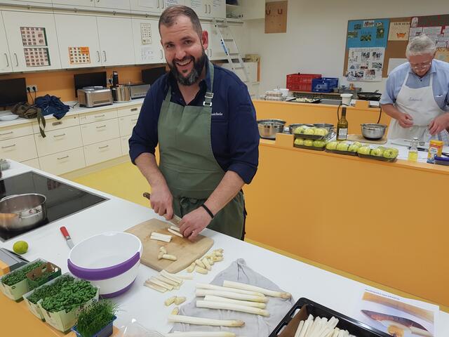 Vorne schneidet Johannes Steichele den Spargel für das zweite Zwischengericht, während hinten Georg Lipp den Sud für die Boskop.Äpfel herrichtet.