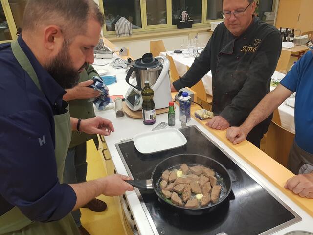 Beim Braten der Kalbsleber nicht zu viel Hitze, aber dafür noch etwas Butter in die Pfanne, und nicht zu lange braten. Johannes Steichele ist der hier der richtige Fachmann Alois Zinsmeister schaut zu ob er noch was lernen kann.