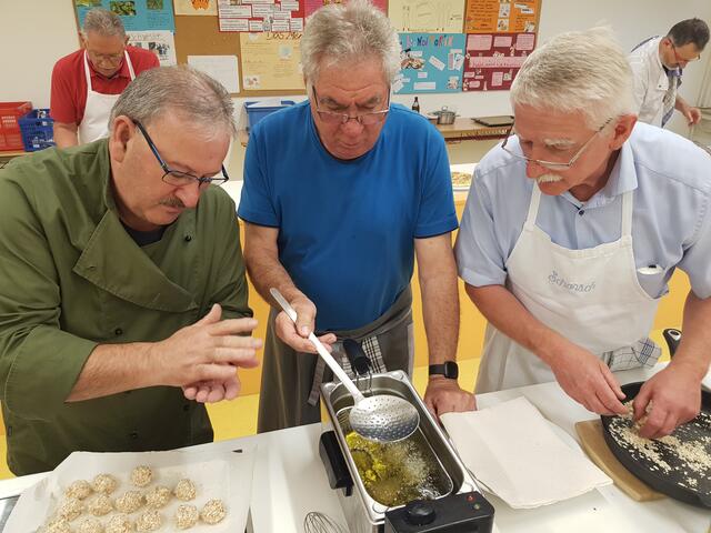Die Saiblingsbällchen werden von Artur Silva hier gedreht und von karl Rupp fritiert. georg Lipp (rechts) hat die Saiblingsbällchen in Reisflocken gewendet.