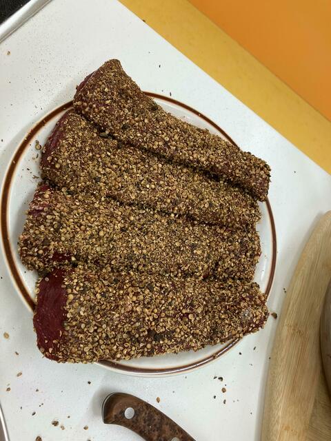 Die Rehrückenfilets mit den gemahlenen Kräutern bevor sie im Butterschmalz rundrum angebraten werden.