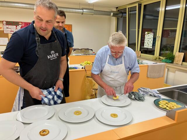 Die gebratene Apfelscheibe als Unterlage für die Leber. Stefan Kaiser kontrolliert ob georg Lipp die Apfelscheibe auch genau in die Tellermitt legt.