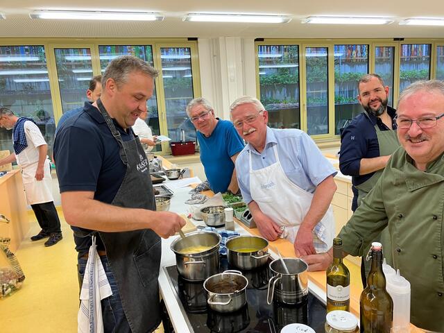 Stefan Kaiser links schlägt gekonnt die Hollandaise für das Zwischengericht "Lauwarmes Steinbuttfilet auf Spargel". Man sieht hier, das kochen viel Spaß machen kann.