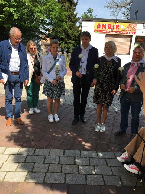 Meitingens Bürgermeister Dr. Michael Higl, seine französische Amtskollegin Michelle Devanne und Marktgemeinderäte legten am Stolperstein für Dr. Max Josef Metzger vor dem Christkönigsinstitut weiße Rosen nieder. | Foto: Andrea Gärtner