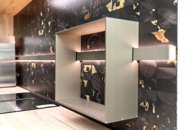 Mit Nischenverkleidungen lassen sich starke Akzente setzen: ganz edel etwa in Schwarz-Gold.
 | Foto: DJD/KüchenTreff/Michael Breuer