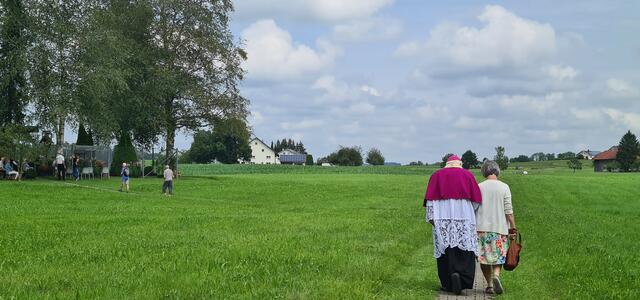 Bischof emer. Dr. Walter Mixa mit Monika Sohler auf dem Weg zum Rasenkreuz von Meggen