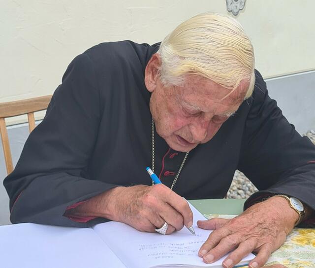Bischof emer. Dr. Walter Mixa beim Eintrag ins Gästebuch Cafe ‘s Himmelreich, Merazhofen