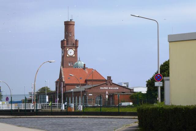 Die Hapag, die ursprünglich Hamburg-Amerikanische Packetfahrt-Actien-Gesellschaft (HAPAG) hieß, war die größte Reederei Deutschlands. Sie betrieb die Hamburg-Amerika Linie. 1889 verlegte diese auf Betreiben ihres Passagedirektors und späteren Generaldirektors Albert Ballin ihren Liniendienst nach New York vom Hamburger Hafen in das zu Hamburg gehörende Cuxhaven. Die Passagiere wurden mit Sonderzügen zum alten Hafenbahnhof in Cuxhaven gebracht. Nach langwierigen Verhandlungen mit der Eisenbahnverwaltung baute der Hamburger  Staat ab 1900 für die Belange der Hapag einen neuen Hafenbahnhof, heute Hapag-Hallen genannt (bahnamtlich: Amerikabahnhof).