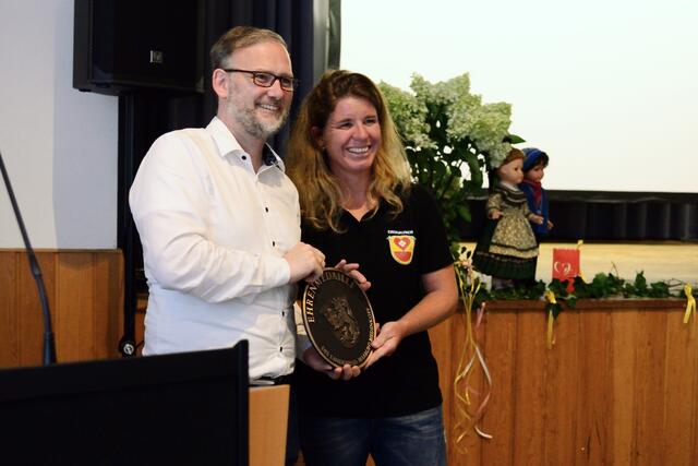 Der Landrat Jens Womelsdorf überreicht die Ehrenmedaille für Erdhausen an Ortsvorsteherin Sabrina Neubauer.