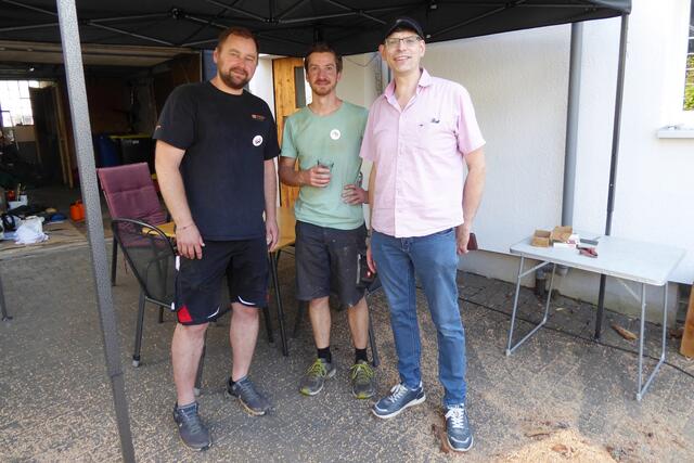In der Haupstraße 10 stehen der Hofeigentümer Maik Wichmann, der dort arbeitende Künstler Leon Fiand und der Sponsor Michael Bienhaus im Gespräch beisammen.
