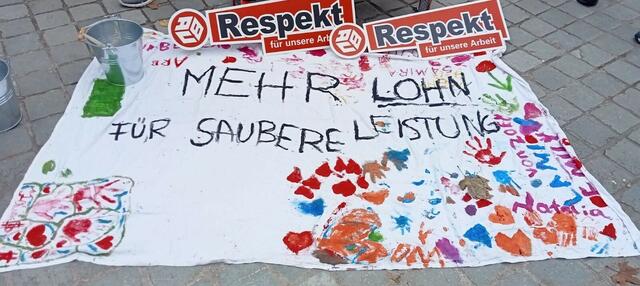 Banner mit der Forderung nach mehr Lohn + mehr Respekt für die Arbeit der Reinigungskräfte | Foto: DGB 