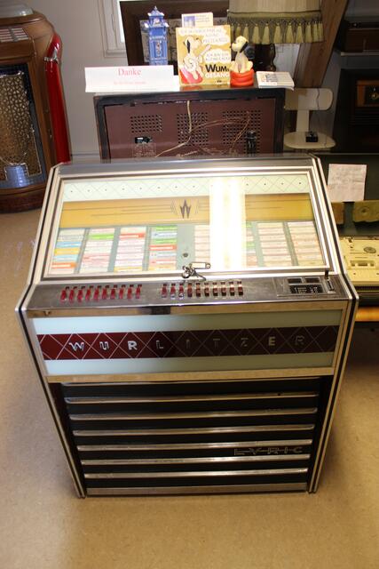 Leihgabe von Otto Killensberger, der diese von Rainer Österreicher Spielautomatenbetreiber aus Nordendorf 2006 erwarb. Diese Wurlitzer stand in der Kellerbar des Gasthauses Miller in Illemad. Bei Führungen für Schulklassen oder bei Kindern kommen immer wieder die Lieder "Ich wünsch mir eine kleine Mizekatze" (Wums Gesang) - oder "Babysitter-Boogie" von Ralf Bendix und "99 Luftballons" von Nena an. 
