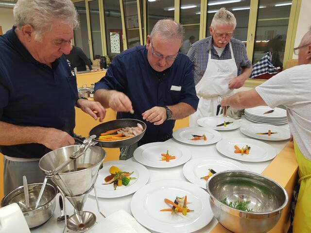 Jürgen Rohm richtet einen "Vorführteller" an - so sollten dann alle angerichtet werden. Karl Rupp, Arthur Silva und Georg Lipp sind auf einer Seite im Einsatz.