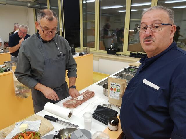 Jürgen Rohm (links) schneidet den Sou Vide gegarten Schweinebauch. Arthur Silva, der Chef der Wertinger Köche, hat immer noch einen Tipp parat.