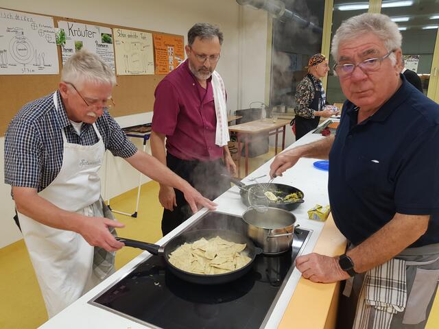Georg Lipp an der Pfanne mit den Schluzkrapfen. Dr. Alois Mossmüller sieht zu und Karl Rupp (rechts) blanchiert die Schlutzkrapfen.