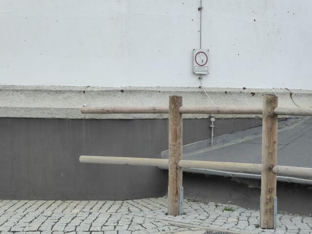 Der Wanderstein am Ende des oberen Holzgeländers.
