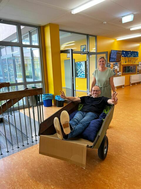 Foto: Lehrerin Sandra Eberhardt-Remmele "karrt" Rektor Peter Reithmeir aus der Mittelschule Meitingen. (Bild: Mittelschule Meitingen)