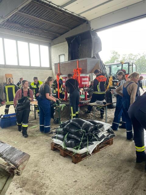 Einsatzkräfte bei der Befüllung der Sandsäcke
