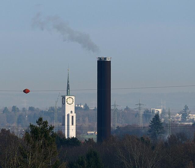 Der Heizturm der Uniklinik überragt die Neusässer Kirche