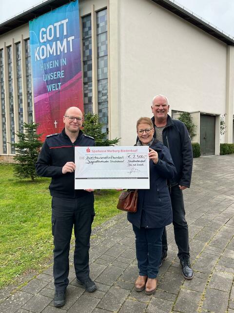 Die stellvertretende Vorsitzende des Kirchenvorstands Silke Schmid und Pfarrer Thomas Peters überreichten Stadtbrandinspektor Patrick Schulz einen symbolischen Scheck in Höhe von 2.500 € | Foto: Herrenwaldgemeinde