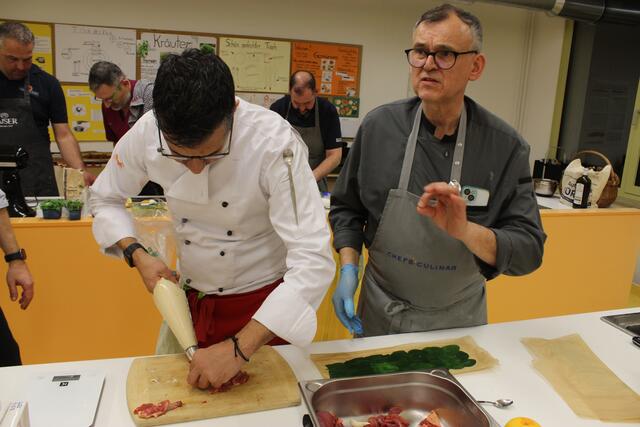 Claudio Erdner füllt hier die Taubenkeulchen während Jürgen Rohm erklärt, worauf man dabei achten sollte.