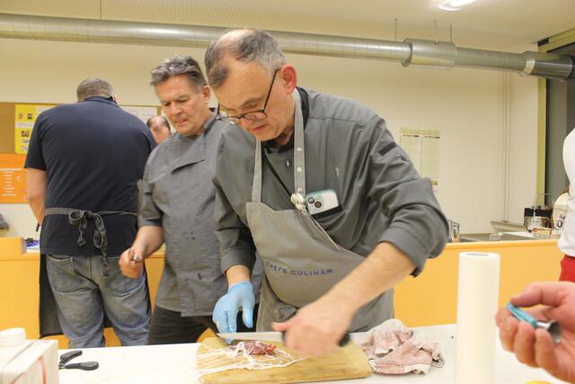 Das einschlagen der Taubenbrüstchen in Schweinenetz, zeigte Jürgen Rohm den Kochbrüdern.