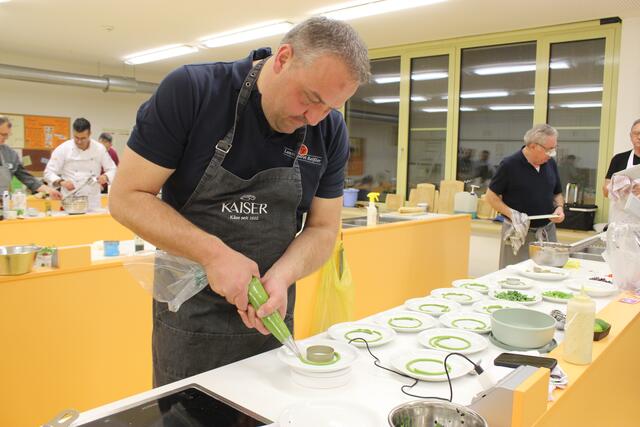 Stefan Kaiser spritzt hier die grüne Soße für die Vorspeise.