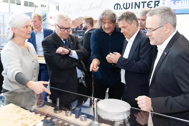 Die Goldschmiede Winter aus Schwabmünchen wurde mit dem Bayerischen Staatspreis für ein innovatives Verfahren zur Herstellung von Ringen aus Edelmetallen ausgezeichnet. Bundeswirtschaftsminister Robert Habeck (4.v.l.) ließ sich das Verfahren von Hermann Winter (3.v.l.) erklären. Mit auf dem Foto (von links): Johanna Winter, HWK-Präsident Hans-Peter Rauch, HWK-Hauptgeschäftsführer Ulrich Wagner und ZDH-Präsident Jörg Dittrich.  | Foto: Sascha Schneider