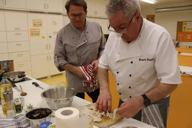 Die Schollenfilets werden von Karl Rupp für das Zwischengericht hergerichtet. Dr. Roland Ziegler sieht zu, wie das gemacht wird.
