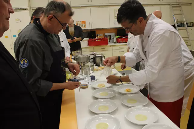 Anrichten heißt das Zauberwort: (Rechts) Claudio Erdner der das Eigelb vorsichtig aus der Plastikfolie löst und ganz auf die Selleriescheibe legt. Jürgen Roll streut ein bißchen Fleur de Sel aufs Eigelb bevor dieses mit einer zweiten Selleriescheibe zu einem "Ravioli" wird. 
