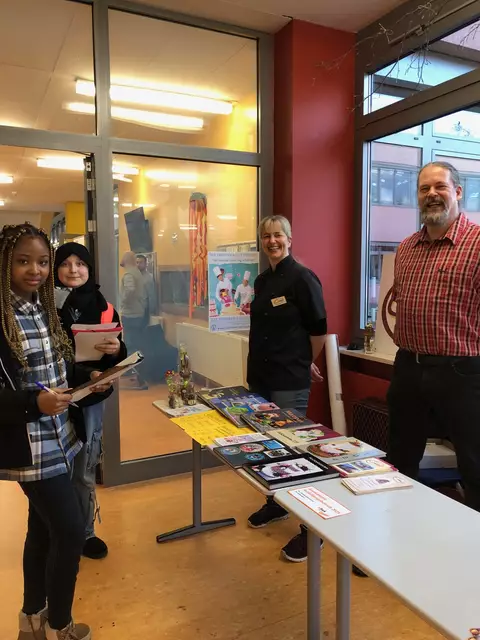 Foto: Zwei Schülerinnen der Mittelschule Meitingen erkundigen sich bei Konditormeisterin Sandra Richter (Café Contur) und Bäckermeister Robert Hierl (Ellgau) über die Kunst des Backens.