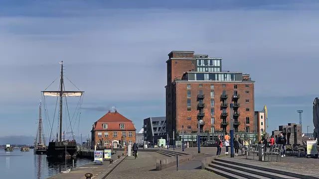 Auf der Promenade am Alten Hafen in Richtung zum Baumhaus. Auf der Poeler Kogge nehmen erste Fahrgäste Platz. Foto: Helmut Kuzina