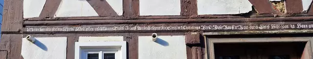 Die gesammte Inschrift des "Ammes Haus"
"Wer den Herrn fürchtet dem wirds wohl gehen und wanner Trosts bedarff wird er gesegentt sein, Sirach im 1. Capitel im 18. Vers. Dieser Bau ist erbaut durch Gottes Hülfe von Johann Georg Irle und dessen Eheweib Anna Gertrauth. Der Zimmermeister ist gewesen Johann Heinrich Zoll den 16ten August Anno 1769".