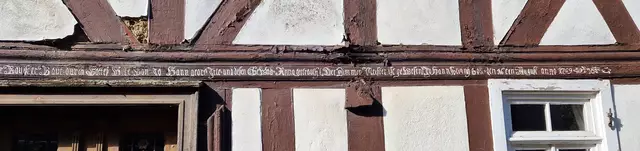 Die gesammte Inschrift des "Ammes Haus"
"Wer den Herrn fürchtet dem wirds wohl gehen und wanner Trosts bedarff wird er gesegentt sein, Sirach im 1. Capitel im 18. Vers. Dieser Bau ist erbaut durch Gottes Hülfe von Johann Georg Irle und dessen Eheweib Anna Gertrauth. Der Zimmermeister ist gewesen Johann Heinrich Zoll den 16ten August Anno 1769".