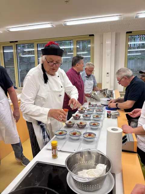 Beim Anrichten des Glasnudelsalates halfen viele mit. Vorne links: Otto Killensberger der für den Glasnudelaslat verantwortlich war. | Foto: Klaus Hill