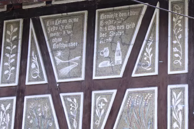 Im Fachwerk ist hier zu lesen: "Ein Leben ohne Feste ist ein weiter Weg ohne Gasthäuser. Genießt den edlen Gerstensaft, des Weines Geist des Brotes Kraft."
