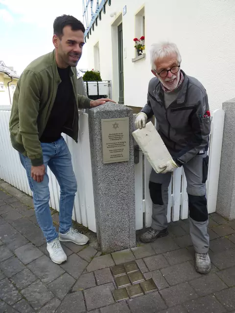 Im Beisein des Battenberger Ortsvorstehers Felix Alexander Horsel enthüllt Norbert Becker die Hinweis- und Gedenktafel zur Stolpersteinverlegung vom 27. Juni 2024.