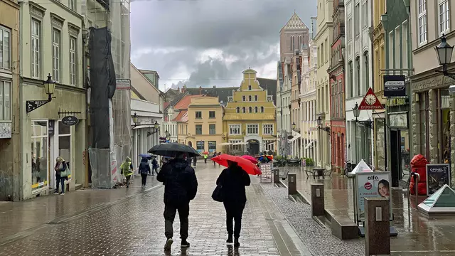 In der Krämerstraße bummeln Stadtbesucher während des Regenschauers. Foto: Helmut Kuzina