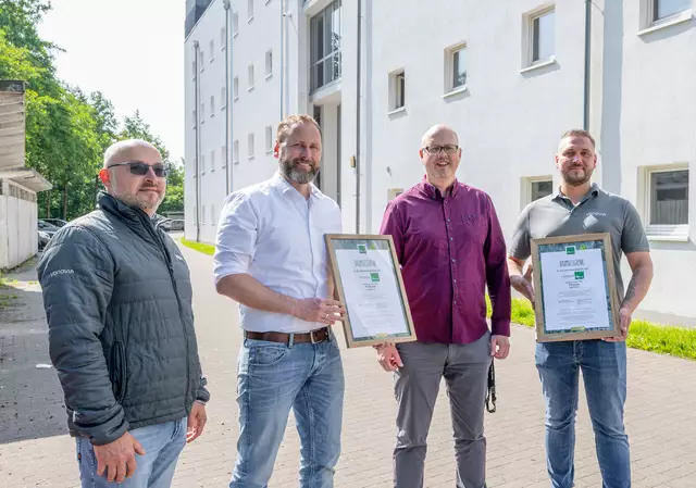Zertifikat mit Wirkung: Vonovia Regionalleiter Oliver Seemann nimmt gemeinsam mit seinem Team das Baumpflanz-Zertifikat für die nachhaltige Fassadenreinigung von Mario Anders der Firma Algenmax entgegen. | Foto: Vonovia/Hake