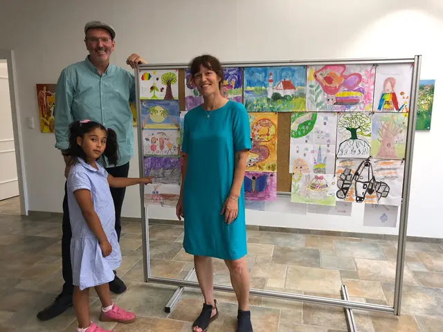 Foto: Mal-Kind Hunya aus der 2 d zeigt stolz ihr buntes Bild, das bei der Ausstellung im Nordendorfer Schloss gezeigt wird. Mit ihr freuen sich Rektor Klaus Katzenschwanz und die Künstlerin.