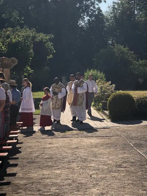 Foto: Die Geistlichen Kaplan Solomon, Kaplan Tony und Pfarrer Norman, der Leiter der Pfarreiengemeinschaft Nordendorf-Westendorf mit den Ministranten beim Einzug zum Gottesdienst im Klosterhof.