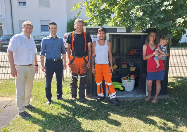 Das Bild zeigt: (von links) Erster Bürgermeister Martin Brenner, Philipp Baumeister, Uli Müller und Ali Baalbaki vom Bauhof-Team, die für die zügige Installation des Spielzeugschranks gesorgt haben, und Kathleen Baumeister mit ihrem kleinen Spielplatzfan.  | Foto: Stadt Burgau