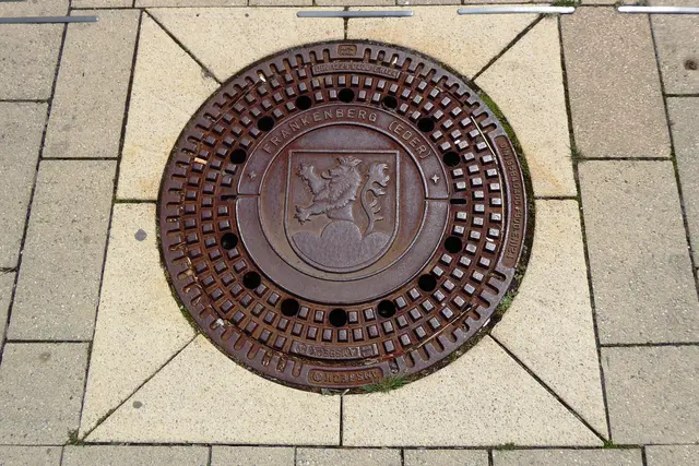 Ein Kanaldeckel auf der Ederpromenade mit dem Frankenberger Wappen.