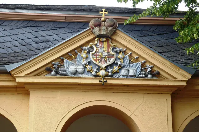 Über den drei rundbogigen Pfeilerarkaden befindet sich im Giebel das Wappen des Fürstbischofs Clemens August von Wittelsbach. 