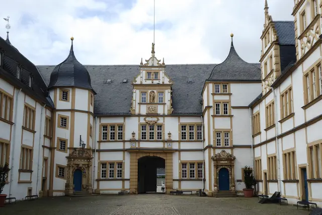 Die vierflügelige Schlossanlage im Paderborner Stadtteil ist von breiten Wassergräben umgeben. Im Innenhof fallen die geschmückten, säulenflankierten Portale der Treppentürme auf.
