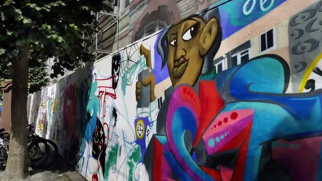 Kinderporträts auf dem Bauzaun in der Schweriner Mecklenburgstraße. Foto: Helmut Kuzina